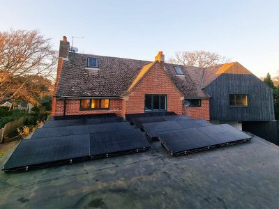 flat-roof-solar-panel-installation-min solar panels on flat roof in front of house
